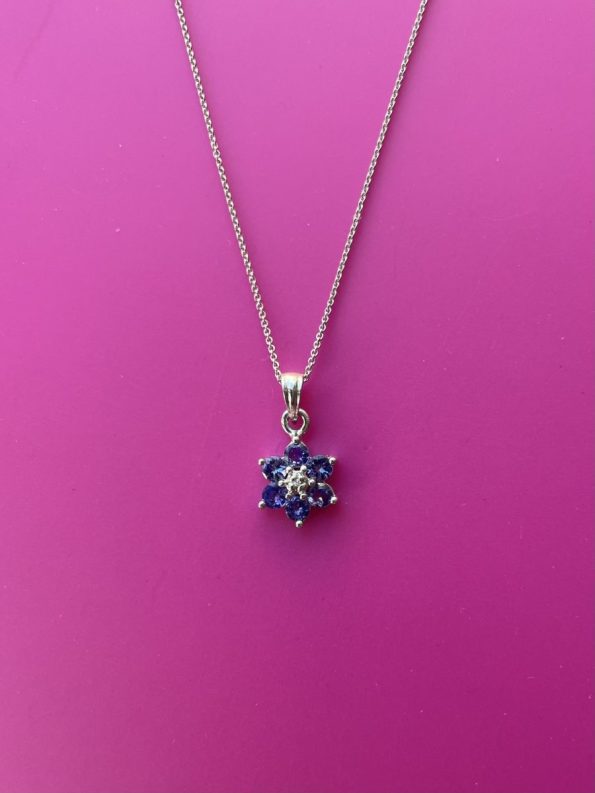 Pretty vintage flower pendant in 9ct white gold set with tanzanite and center diamond. in perfect condition 1cm across flower